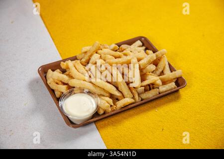 Garlic mayo street food cart potato chip fries on a yellow and white background. Stock Photo
