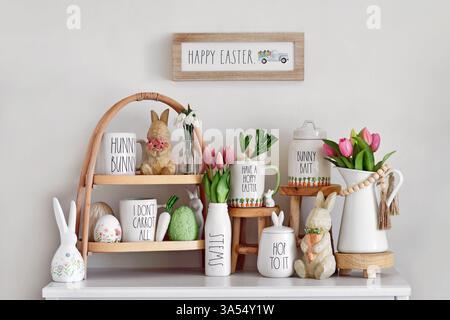 Germany - March 2025: Seasonal Easter home decoration with tray tier, mugs with text, bunny, eggs and tulip spring flowers Stock Photo