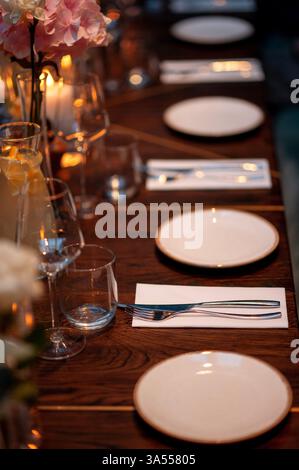 Wedding table setting with plates and cutlery on wooden table Stock Photo