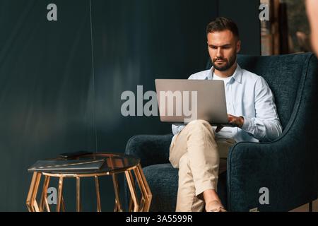Businessman is sitting and working by using laptop. Stock Photo