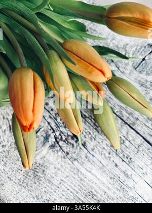 A bouquet of beautiful tulips perfect for Valentine's day, Birthday, Mother's day, wedding, anniversary isolated on wooden background. Copy space. Stock Photo