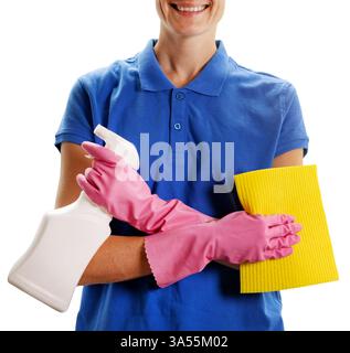 cleaning service. smiling female janitor in blue uniform standing with cloth and detergent in hands. isolated on white background Stock Photo