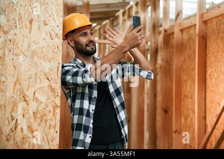 Using the smartphone. Industrial worker in wooden warehouse. Stock Photo