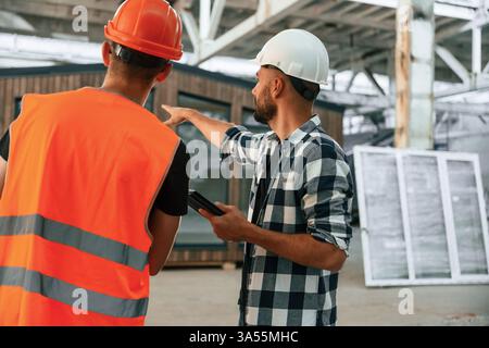 Two workers are in the industrial wooden warehouse. Stock Photo