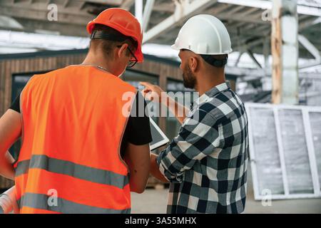 Two workers are in the industrial wooden warehouse. Stock Photo