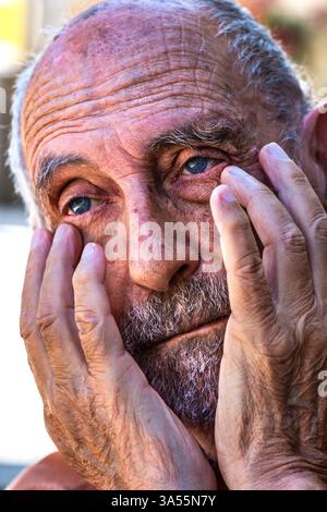 Sad, desolate looking older bearded and balding man with head in hands - Indre-et-Loire (37), France. Stock Photo
