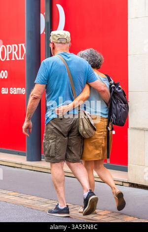 Mature couple walking together with arms around each other - Tours, Indre-et-Loire (37), France. Stock Photo