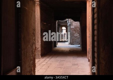 A small calle in Venice winds between historic buildings, leading to a quiet canal. High quality photo Stock Photo