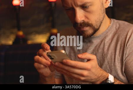 Serious young man using phone Stock Photo