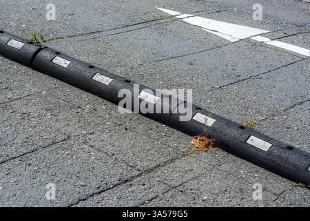 Narrow black colored metal curb separates the pedestrian area from the bike lane. Stock Photo