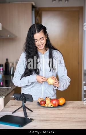 Food blogger recording a video about healthy eating and peeling an apple Stock Photo