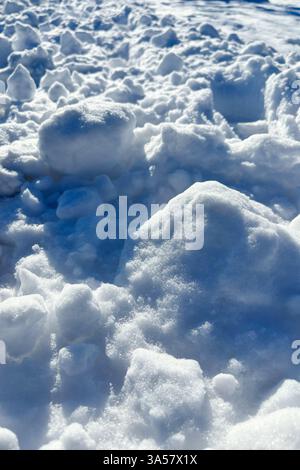 Natural fresh snow texture, snowballs close up, surface of snow crust in sunny day. Snowy background, winter backdrop Stock Photo