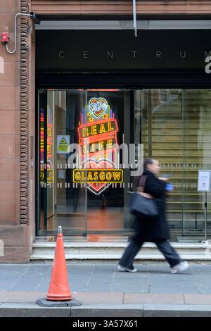 Woman passing a We Love Real Life Glasgow neon sign, Queen Street, Glasgow, Scotland, UK, Europe Stock Photo