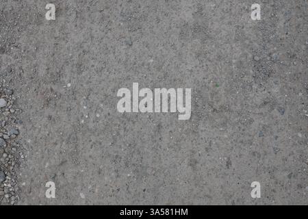 A grey and white background with a few rocks scattered around. The background is a mix of grey and white, with some areas being darker than others Stock Photo