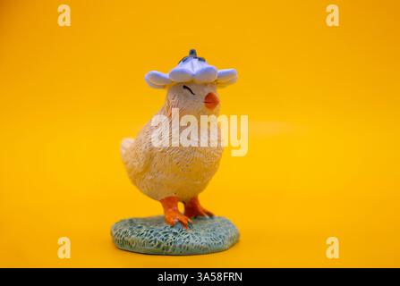 A cute decorative Easter chick on a warm solid yellow background. A perfect for Easter and spring-themed cards, wallpaper and designs Stock Photo