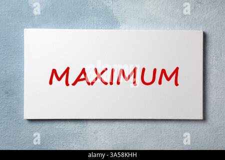 Canvas with word Maximum on light blue textured background Stock Photo