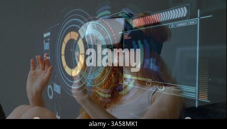 Woman using VR headset interacting with digital interface, exploring virtual reality Stock Photo