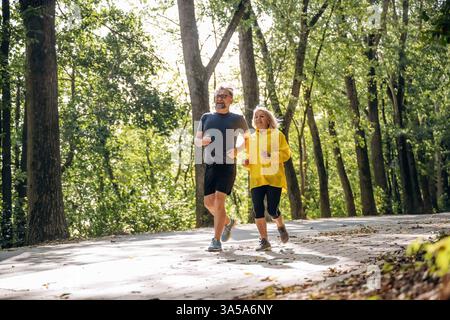 Jogging, conception of sport. Senior couple together outdoors at nature. Stock Photo