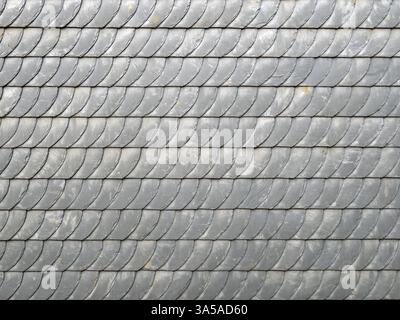 Gray slate shingles form a pattern on a facade, backgrounds Stock Photo