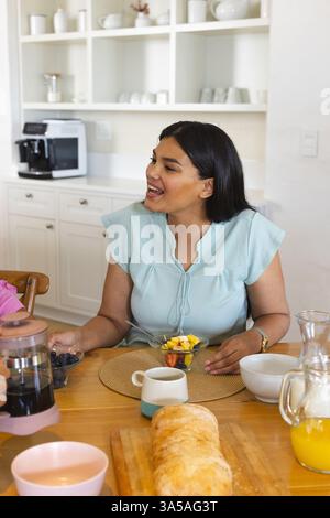Asian woman enjoying breakfast with family at home, smiling and talking happily Stock Photo