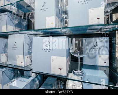 Freiburg, Germany - Feb 10, 2025: Shelves are stacked with Zwiesel Glas boxed glassware and displayed wine glasses in a refined retail setting with so Stock Photo