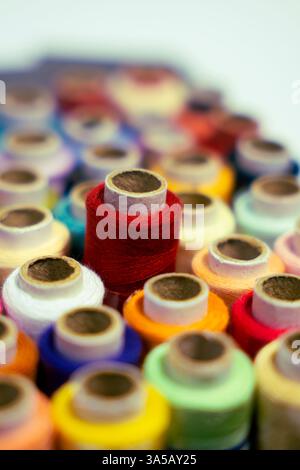 A photo of colorful thread reels displayed on a white background. Great for showcasing the arrangement in crafting or sewing projects. Stock Photo