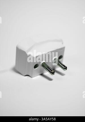 Photo of a universal travel adapter, showcasing its sleek and portable design on a white background. Great for travel accessories websites and tech pr Stock Photo