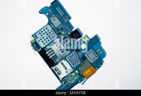 A high-quality close-up of a mobile phone circuit board, highlighting its complex design and electronic components on a white background. Ideal for te Stock Photo