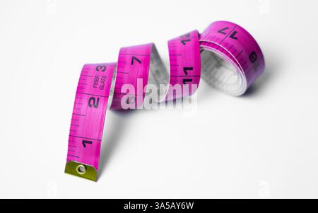 A high-quality photo of a measuring tape, clearly displaying both inch and centimeter markings on a white background. Great for international projects Stock Photo
