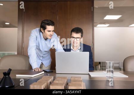Two workmates reviewing important data, documents, or presentations using laptop Stock Photo