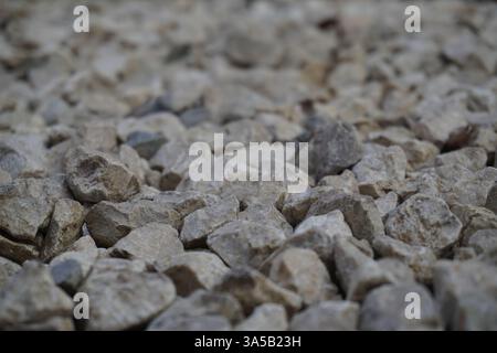 Close-up light beige and white small stones, gravel rugged background Texture. irregularly shaped, light colored stones Stock Photo