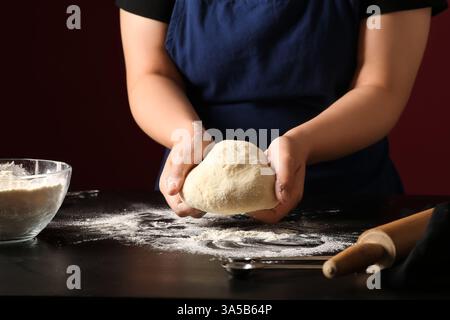 Woman preparing traditional cinnamon rolls in kitchen Stock Photo