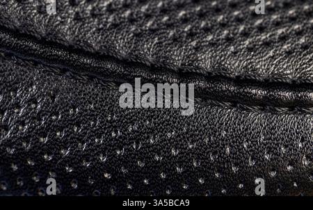 a piece of black leather for the production of shoes and other leather products, treated leather with perforation to give a beautiful appearance Stock Photo