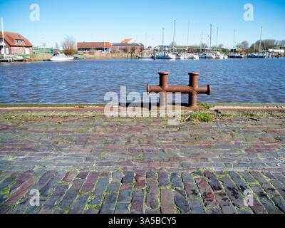 Low angle view of a cross bollard at the harbor basin in East Frisia. Stock Photo