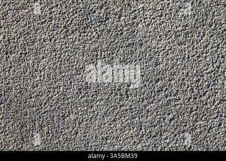 Grey stone surface, texture, background. Relief, grainy rocky wall surface of granite stone. Roug volcanic rock of light-grey color. Grey backdrop Stock Photo