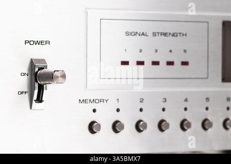 Close-up of a classic audio component showcasing details of its knobs, signal strength indicator, and power switch, representing vintage aesthetics an Stock Photo