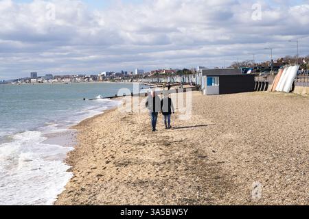 couple walk along pebbled beach at Southend-on-sea Essex England UK Stock Photo