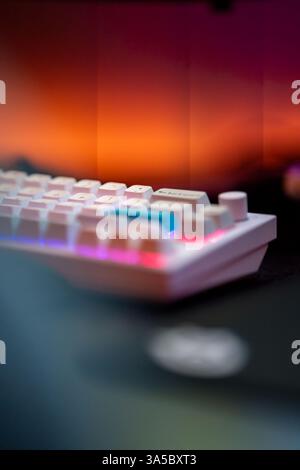 Close-up of a white mechanical keyboard with blue accent keys and RGB lighting. Stock Photo