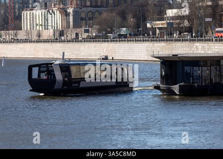 Moscow, Russia. 9th of March, 2025. A Russian electric commuter boat 'Sinichka' sails on the Moskva River in front of embakment in Moscow, Russia, 25 October 2023. Vessels, built by Russian shipyard 'Emperium', are the first units of a planned fleet of 20 that serve the capital city and other nearby communities Stock Photo