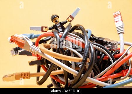 Lego technician trying to fix a bunch of tangled ethernet cables. Illustrative editorial. January 20, 2025 Stock Photo