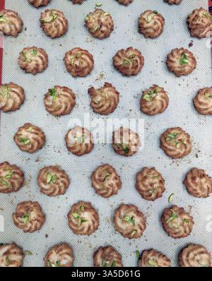 Swirl cookies made from rich dough and topped with nuts are laid out on a baking sheet, ready for cooling and serving. Stock Photo