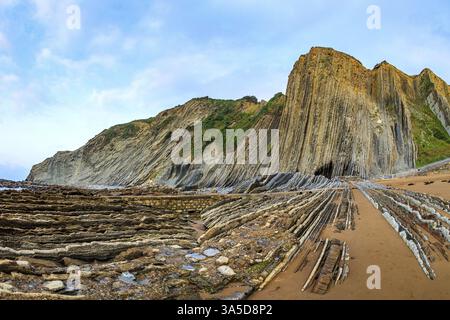 Low tide in the Atlantic. Flysch - unique landscape of underwater rocks exposed at low tide. Incredibly bizarre coastal cliffs. Playa Zumaya. The Basq Stock Photo