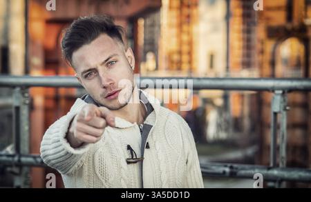 Handsome young man pointing fingers at you, towards the camera, with confident look Stock Photo
