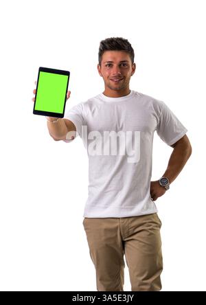 Smiling young man holding and showing tablet PC or ebook reader, standing isolated on white background Stock Photo