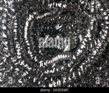 close-up macro view of stainless steel coiled scrubbing brush or scouring pad in full frame background, abrasive cleaning tool for kitchens, industria Stock Photo