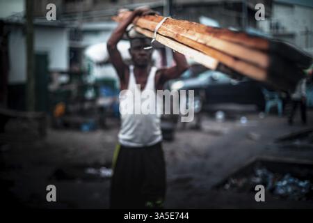 Man carrying wooden planks, everyday life in Kinshasa, Democratic Republic of the Congo, DR Congo Stock Photo