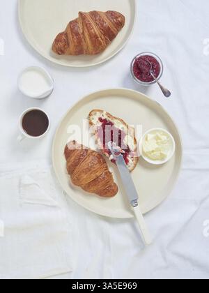 Continental breakfast served on white tablecloth croissants, butter, jam and cup of coffee Stock Photo