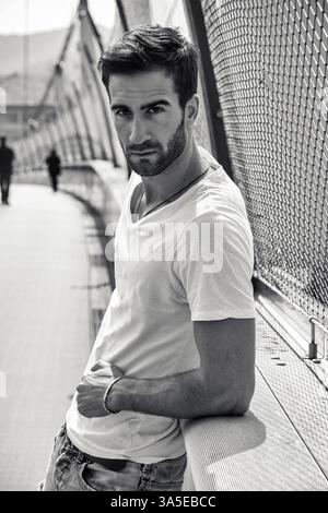 Handsome bearded young man outdoors in urban environment looking at camera Stock Photo