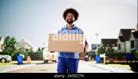 African American man in uniform smiling while delivering packages by van. Stock Photo