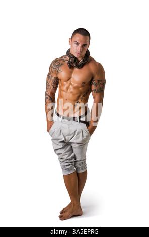 Full Length Portrait of Muscular Man with Shaved Head Standing in Studio with White Background Wearing White Pants and Small Boa or Python Snake Wrapp Stock Photo